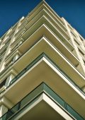 A photo looking up at the corner of a building with many balconies