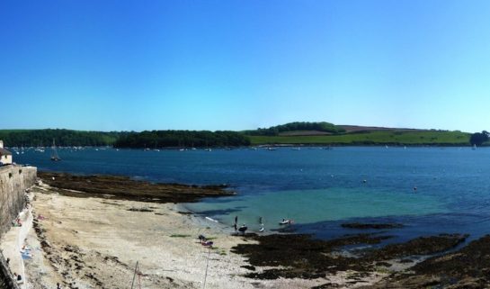 Image is overlooking the sea and beach on a sunny day in Cornwall